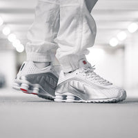 ike Shox R4 White Bright Crimson Metallic Silver on feet in studio met witte outfit en rode details
