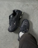 Sneaker on-feet met cargobroek en donkere vloer, focus op de demping en diepe grijstinten van de zool