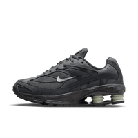 Zijaanzicht van de Nike Shox Ride 2 in donkergrijs met Shox-unit in jadegroen, gefotografeerd tegen witte achtergrond