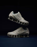 Beide sneakers zwevend vastgelegd in studioverlichting, met focus op het contrast tussen de Sail upper en zilveren Shox-unit