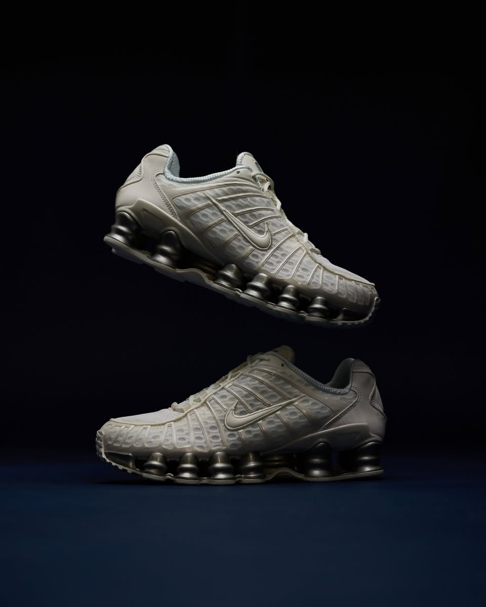 Beide sneakers zwevend vastgelegd in studioverlichting, met focus op het contrast tussen de Sail upper en zilveren Shox-unit