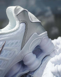 Close-up van de Nike Shox TL White Metallic Silver Max Orange met focus op de witte mesh en metallic swoosh details