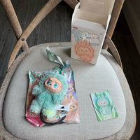 Pop Mart Labubu Big Into Energy Series Serenity – in‑hand shot van de pendant (~17 cm) met zachte textuur, pastelkleuren en metalen hangerring