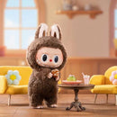 Pop Mart Labubu Tasty Macarons – uit de box genomen vinyl figuur naast doos, met pastel macarons‑motief en zachte kleuren