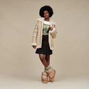 Model met oversized outfit en UGG Dipper Boots in beige/chestnut combinatie, gefotografeerd in studio met lichte achtergrond
