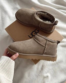 Close-up van UGG Ultra Mini Antilope op wit beddengoed, cozy en minimalistische sfeer