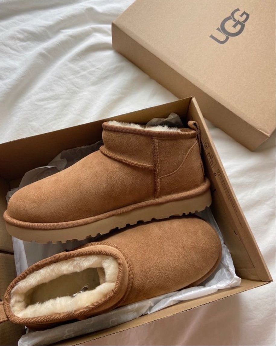 Close-up van UGG Ultra Mini Chestnut op wit beddengoed, sfeervol beeld met zachte winteruitstraling