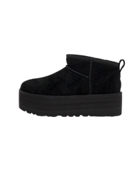 Zijaanzicht van de UGG Classic Ultra Mini Platform in diepzwarte suède, gefotografeerd tegen witte achtergrond met focus op de plateauzool