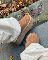 Detailbeeld van UGG Classic Platform gedragen op kleurrijk herfsttapijt, in beweging vastgelegd met focus op comfort en stijl