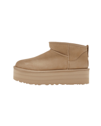 Zijaanzicht van de UGG Classic Ultra Mini Platform Mustard Seed met verhoogde zool in studio-opstelling, perfect zichtbaar in neutrale belichting