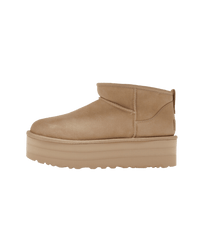 Zijaanzicht van de UGG Classic Ultra Mini Platform Mustard Seed met verhoogde zool in studio-opstelling, perfect zichtbaar in neutrale belichting