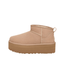 Zijkant van de UGG Classic Ultra Mini Platform in zandkleur, minimalistisch studiobeeld met focus op verhoogde plateauzool