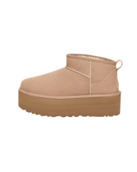 Zijkant van de UGG Classic Ultra Mini Platform in zandkleur, minimalistisch studiobeeld met focus op verhoogde plateauzool