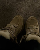 On-feet foto van de UGG Lowmel Antilope gedragen op een donkere vloer, benadrukt de contrasten tussen zool en bovenwerk