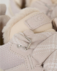 Close-up van UGG Lowmel Ceramic 1144032-CERA met focus op de suède structuur, stitching en fleece binnenvoering, gedetailleerde productfoto door Snrkickz.