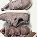 Flatlay van gestapelde UGG Campfire sneakers, met zicht op suède structuur, lichtgrijze zool en subtiel logo bij de hiel