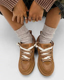 Bovenaanzicht van gedragen UGG Lowmel Lo Chestnut met witte sokken, model zittend met voeten naast elkaar op beige vloer