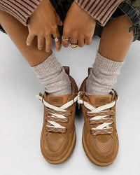 Bovenaanzicht van gedragen UGG Lowmel Lo Chestnut met witte sokken, model zittend met voeten naast elkaar op beige vloer