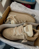 Bovenaanzicht van UGG Lowmel Sand in doos, met zicht op fluffy voering en logo aan de zijkant van de hak