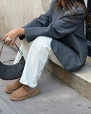 UGG Tasman Chestnut gedragen bij een grijze oversized blazer en gucci tas voor een moderne urban look