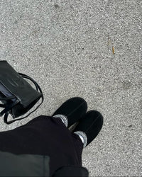 UGG Tazz Slipper Black 1122553-BLK gedragen on-feet in buitenomgeving, zwarte suède slipper met verhoogde zool en opvallende braid detail, vastgelegd door Snrkickz.