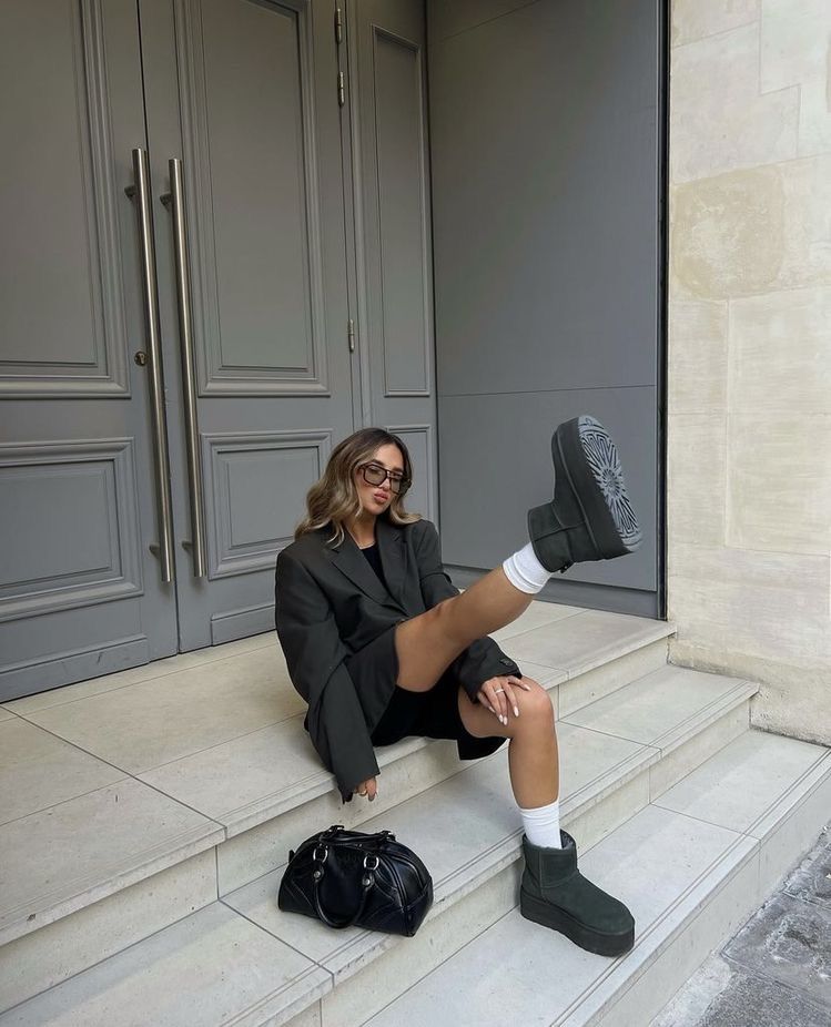 UGG Ultra Mini Black gecombineerd met grijze wollen sokken en city outfit op de stoep